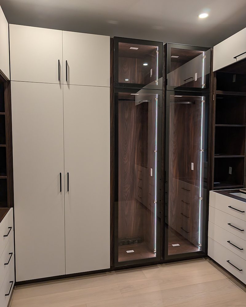 Glass-front wardrobe towers with integrated lighting
