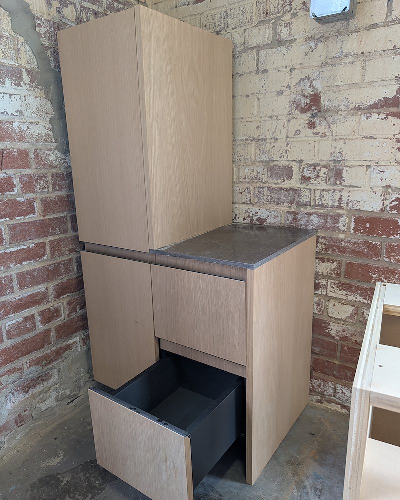 White oak frameless cabinet with stone top and integrated pulls