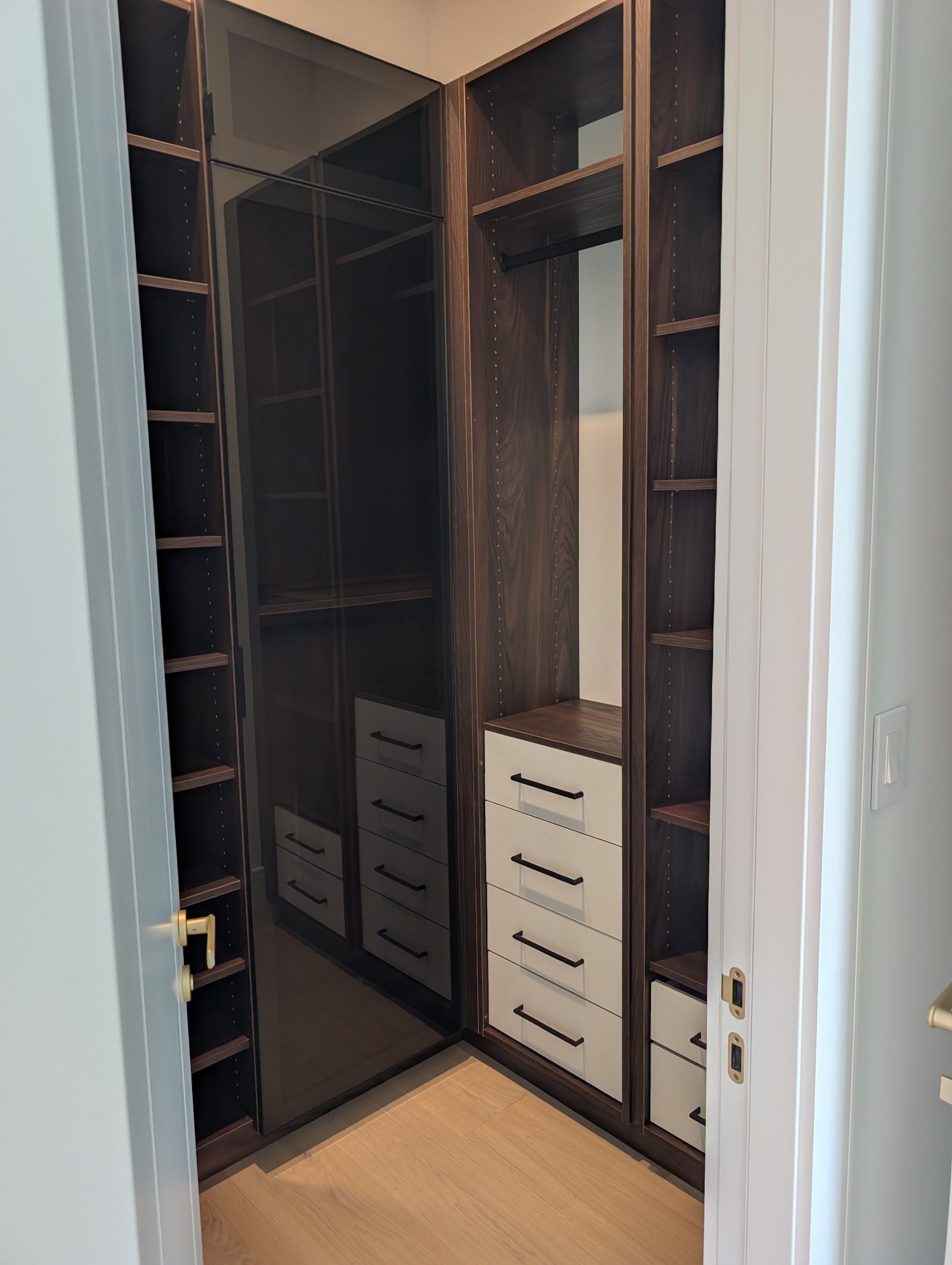 Walk-in closet with smoke glass wardrobe and drawer towers