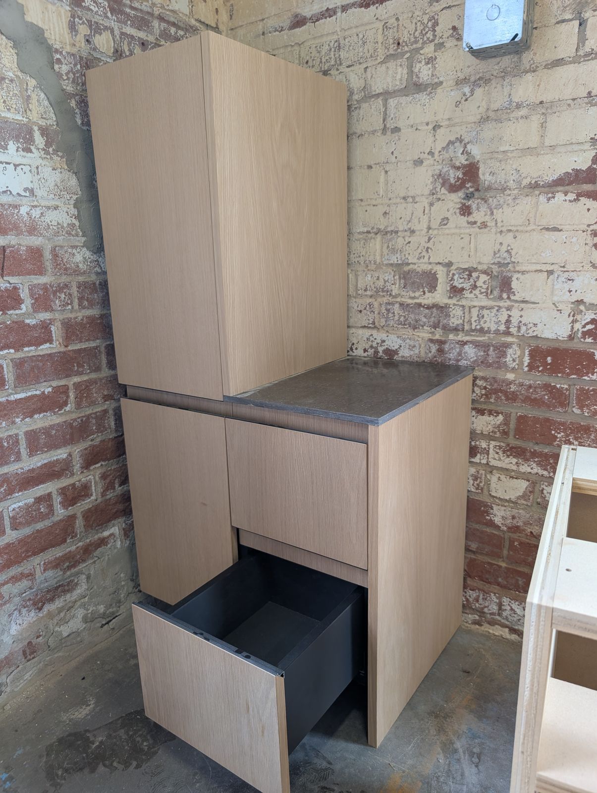 White oak frameless cabinet with stone top and integrated pulls